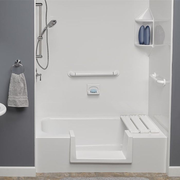 Converted tub with a low step-through, folding seat and grab bars
