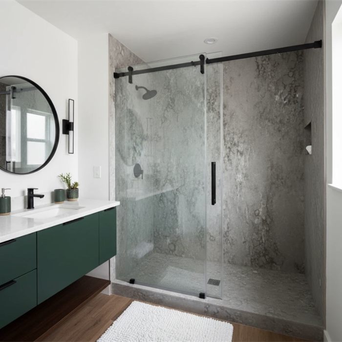 Walk-in shower with stone-look wall panels and a black frameless door