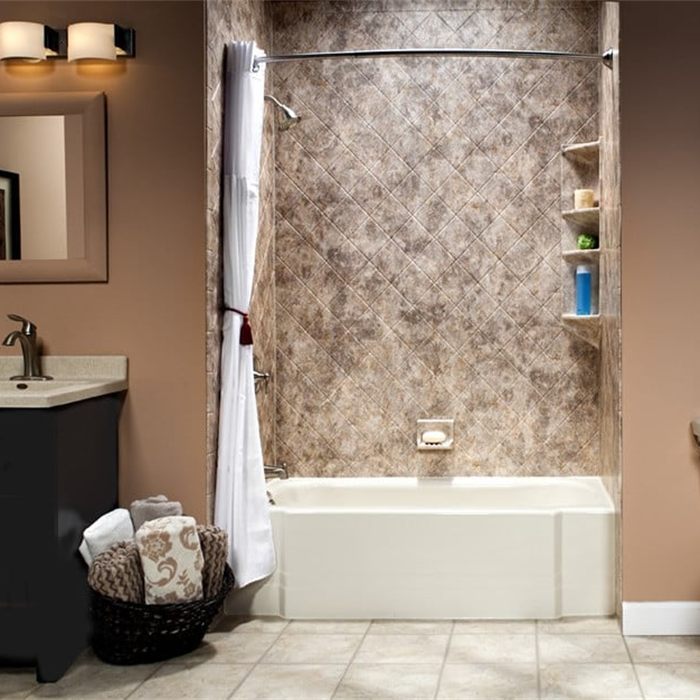 Stone-look wall surround panels in a diamond pattern above a bathtub