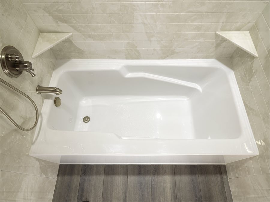 Replacement alcove bathtub with a tiled surround and corner shelves