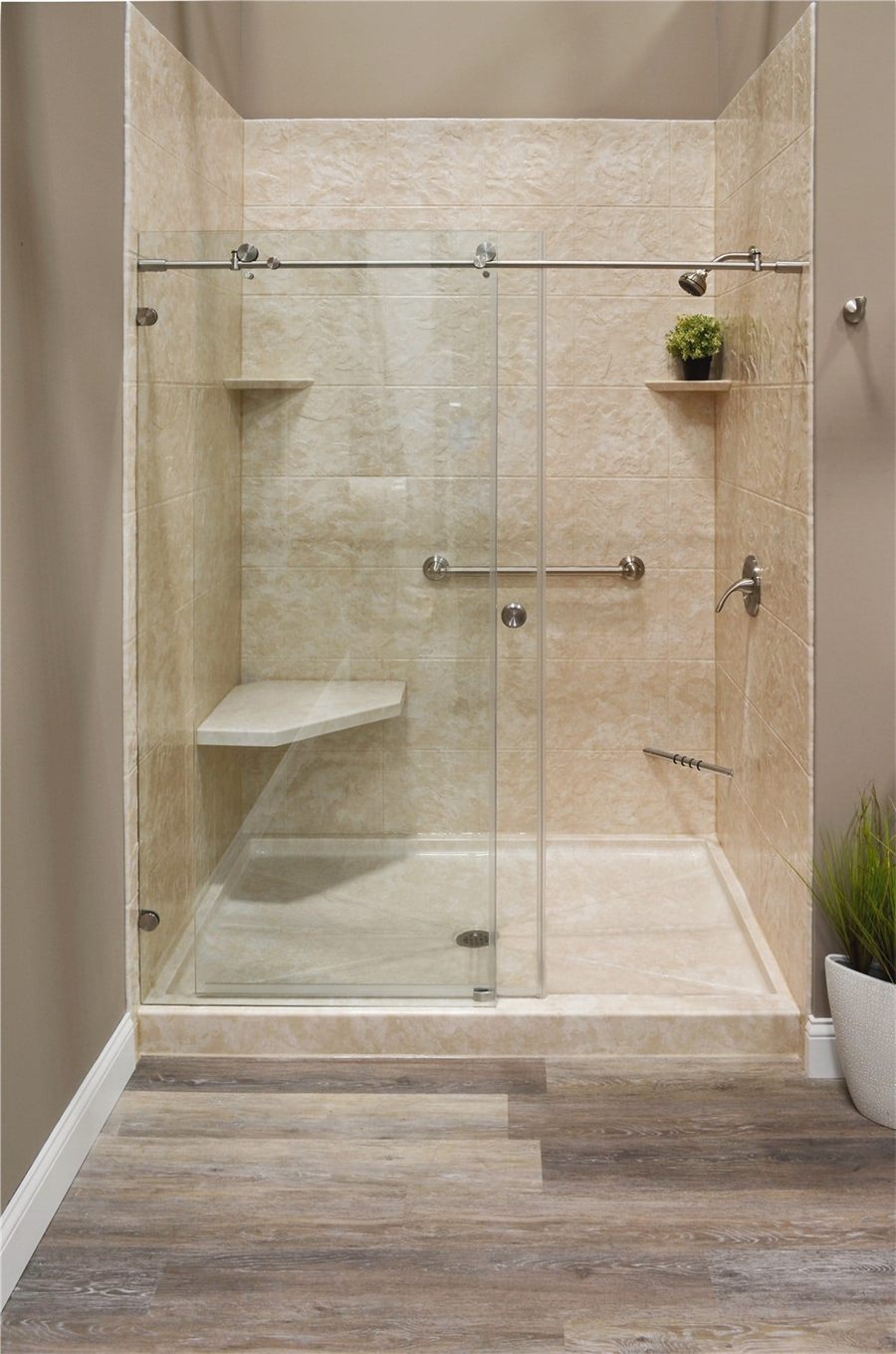 Large shower with a built-in bench and frameless sliding glass in a primary suite